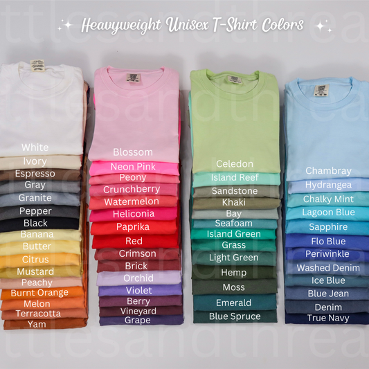 Stacks of heavyweight unisex t-shirts in various colors on a gray background.